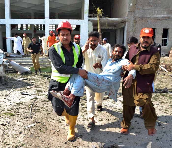 <p>Pakistani rescuers help an injured man at the bomb blast site. Witnesses to the restaurant blast said it occurred soon after a man parked a car outside the restaurant. (AFP Photo)</p>